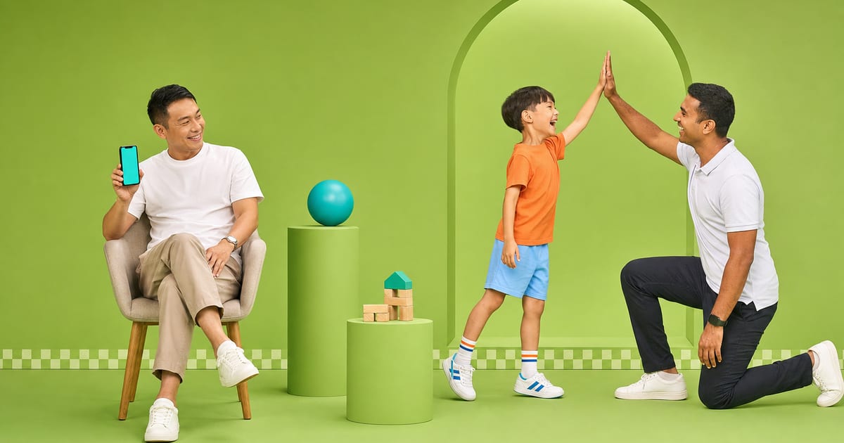 A coach high-fives a boy while a parent checks the class on his phone